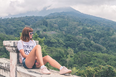 woman sitting on bridge near mountain thumbnail