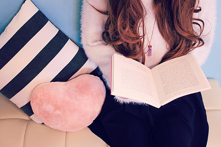 open page of book on woman's lap thumbnail