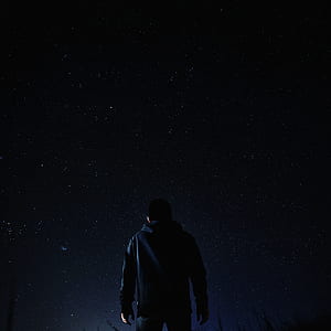 man in black hoodie looking at starry sky thumbnail