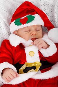 sleeping baby wearing Santa Claus costume thumbnail