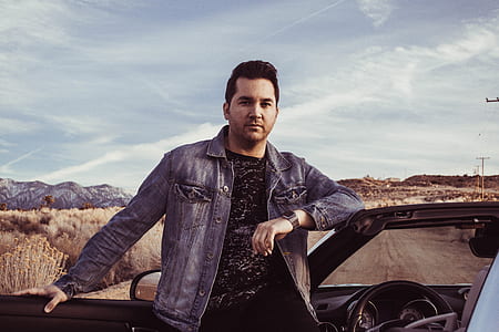 man standing beside car thumbnail