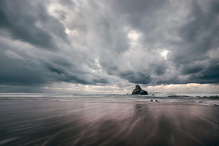 landscape photography of body of water and rock formation thumbnail