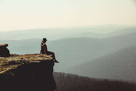 Woman Sitting on Edge of Rock Formation thumbnail
