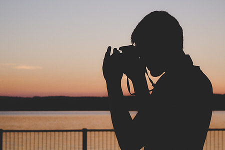 silhouette of a man taking pictures during sunset thumbnail