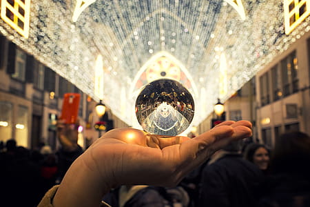 Person Holding Round Silver-colored Accessory thumbnail