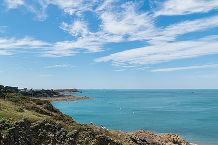 mountain beside sea under blue sky thumbnail