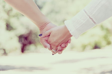 selective photography of couple holding hands thumbnail
