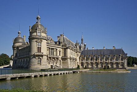 gray castle beside body of water under blue sky during daytime thumbnail