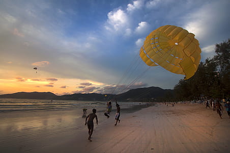 people playing on seashore during golden hour thumbnail