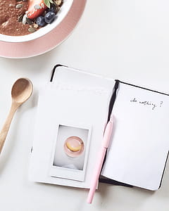 Pink Pen on Top of White and Black Book thumbnail