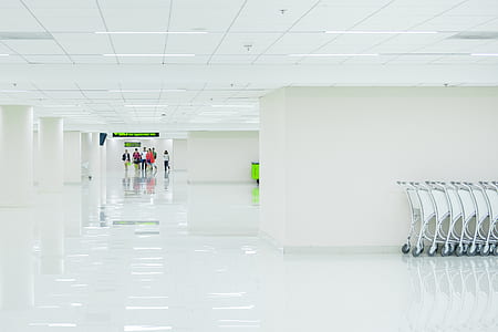 group of people walking on white floor tiles surrounded by white painted wall thumbnail