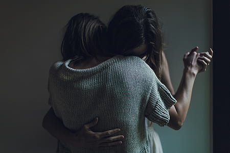 two person hugging in front of white painted wall thumbnail