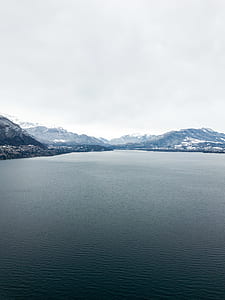 body of water surrounded with mountains thumbnail