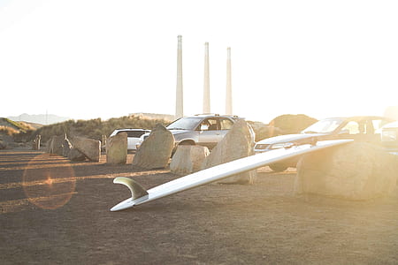 white surfboard near several vehicles thumbnail