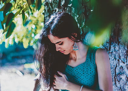 selective focus photo of woman standing beside tree thumbnail