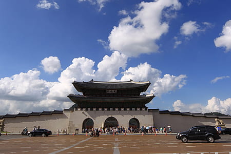 people standing and walking outside temple under cloudy sky thumbnail