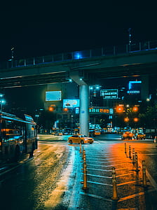 yellow taxi sedan under railway bridge thumbnail