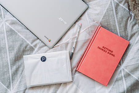 gray Chromebook beside book thumbnail