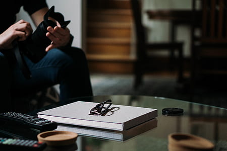 person holding DSLR camera in front of glass-top table thumbnail