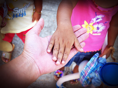 focus photography of person of man holding hand of girl during daytime thumbnail