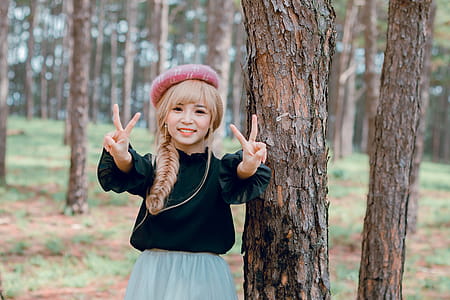 Girl Wearing Black Shirt Standing Near Tree thumbnail