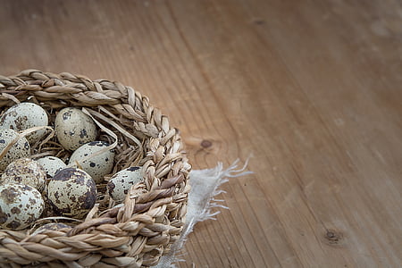clutch of quail eggs in basket on brown wooden surface thumbnail