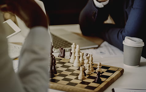 people wearing white and black long-sleeved shirts playing chess thumbnail
