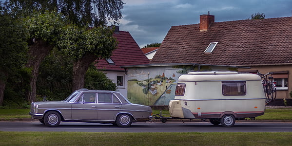 classic grey sedan on road with travel trailer thumbnail