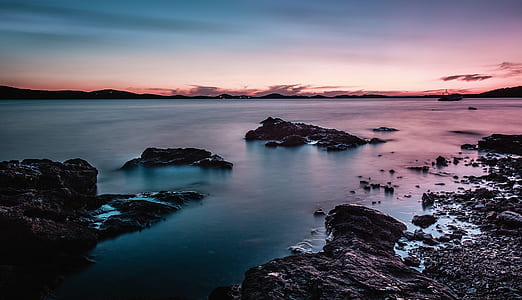 Rock Formation On Body Of Water During Golden Hour thumbnail
