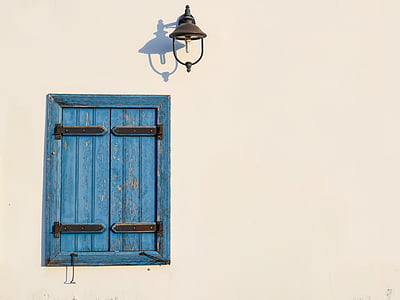 closed blue wooden window under brown sconce thumbnail