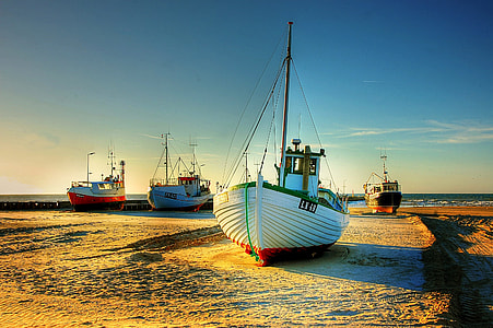 four assorted sail boats photo during dusk thumbnail