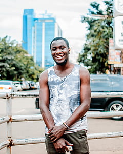 Man Wearing Gray and White Tank Top Near Black Vehicle thumbnail
