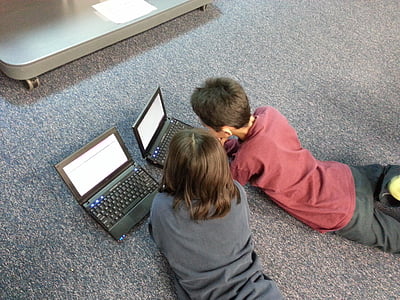 two boys wearing shirt infront laptop thumbnail
