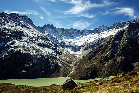 brown and gray mountains near body of water under blue sky during daytime thumbnail