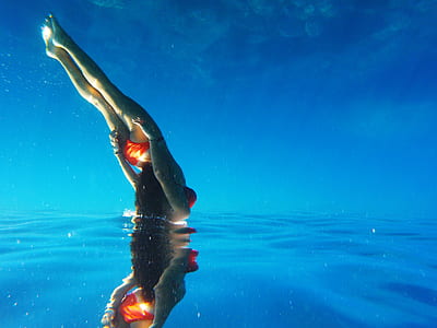 woman wears orange 2-piece bikini diving thumbnail