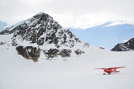 red stunt plane on snowy mountain thumbnail