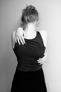 woman in black tank top hands on her back thumbnail