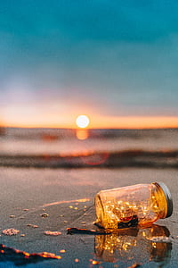 mason jar on shore under blue sky during golden hour thumbnail