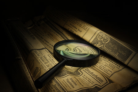 photography of magnifying glass on printed brown paper thumbnail