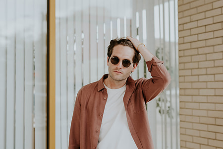 man holding his hair wearing brown button-shirt thumbnail