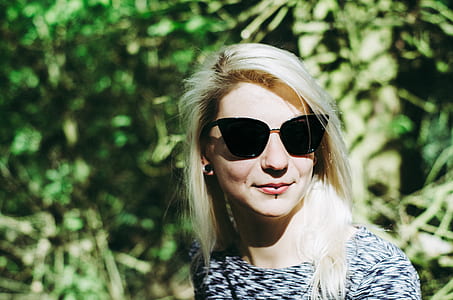 woman smiling near leaves during day thumbnail