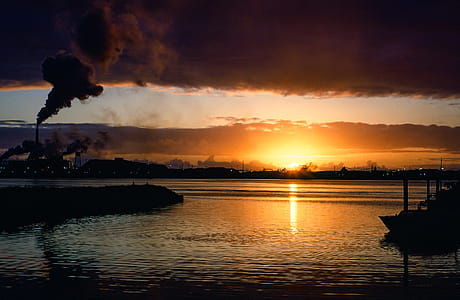 Industrial factory smoke from smokestacks over sunset sky thumbnail