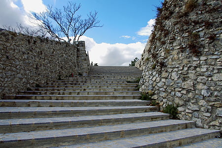 gray concrete stair beside brown concrete wall during daytime thumbnail