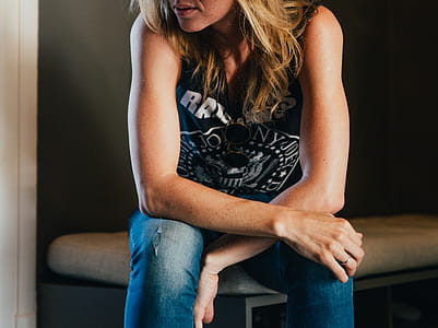 A young blonde woman in punk wear sitting with her elbows on knees thumbnail