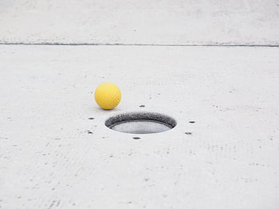 round yellow ball beside hole thumbnail