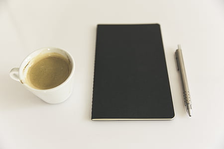 black notebook beside mug and pen thumbnail