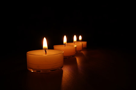 close up photo of four lighted tealight candles thumbnail