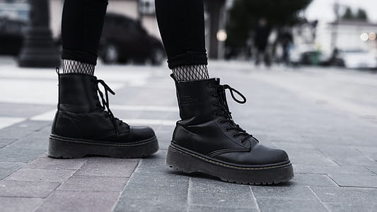 person wearing black leather work boots thumbnail