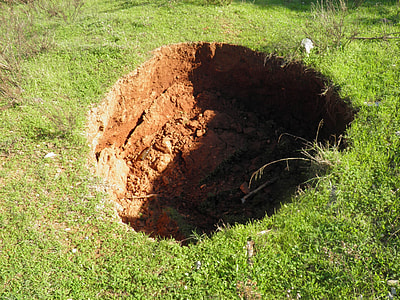 deep hole surrounded with green grass thumbnail