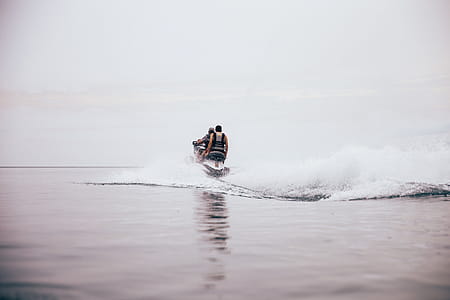 Jet ski making waves on the beach on an overcast day thumbnail